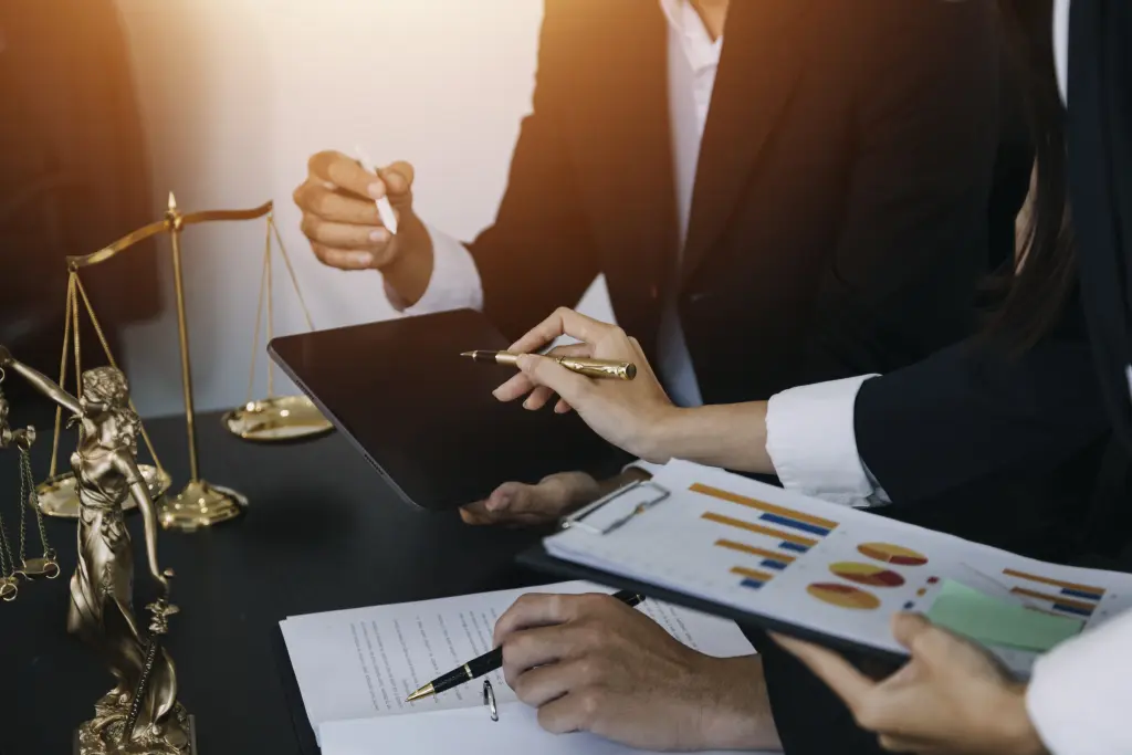 Dois empresários discutindo documentos financeiros e gráficos em uma mesa, cena comum ao realizar o Planejamento Tributário.