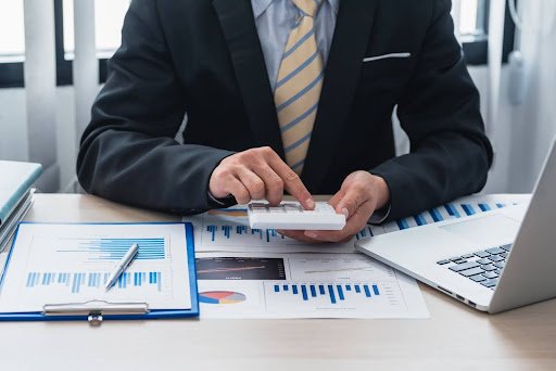 Mãos contando ou organizando notas de Real. A atenção em transações é crucial para evitar pagamento indevido ou a maior em cobrança de taxas.