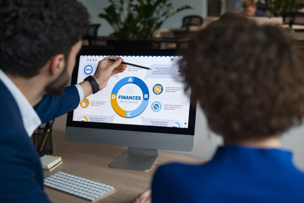 Profissionais analisam o infográfico financeiro no monitor para definir o planejamento tributário estratégico de sua empresa.