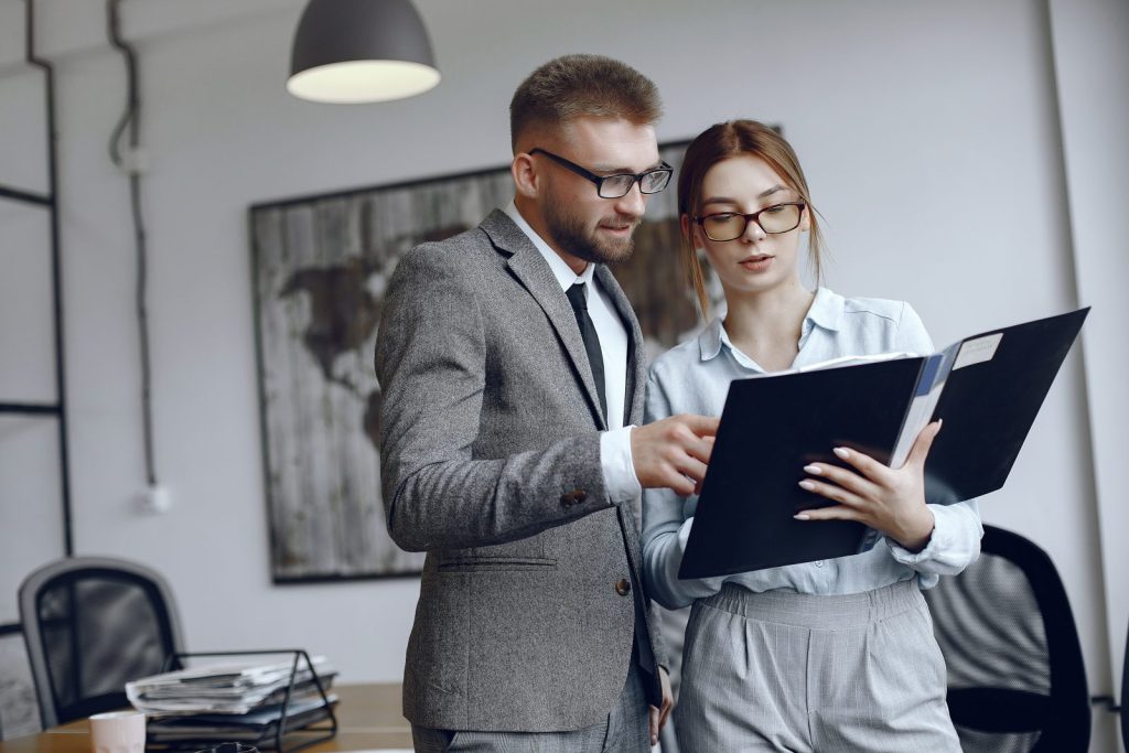 Advogados analisam contrato, representando a importância de um advogado para empresa na consultoria.