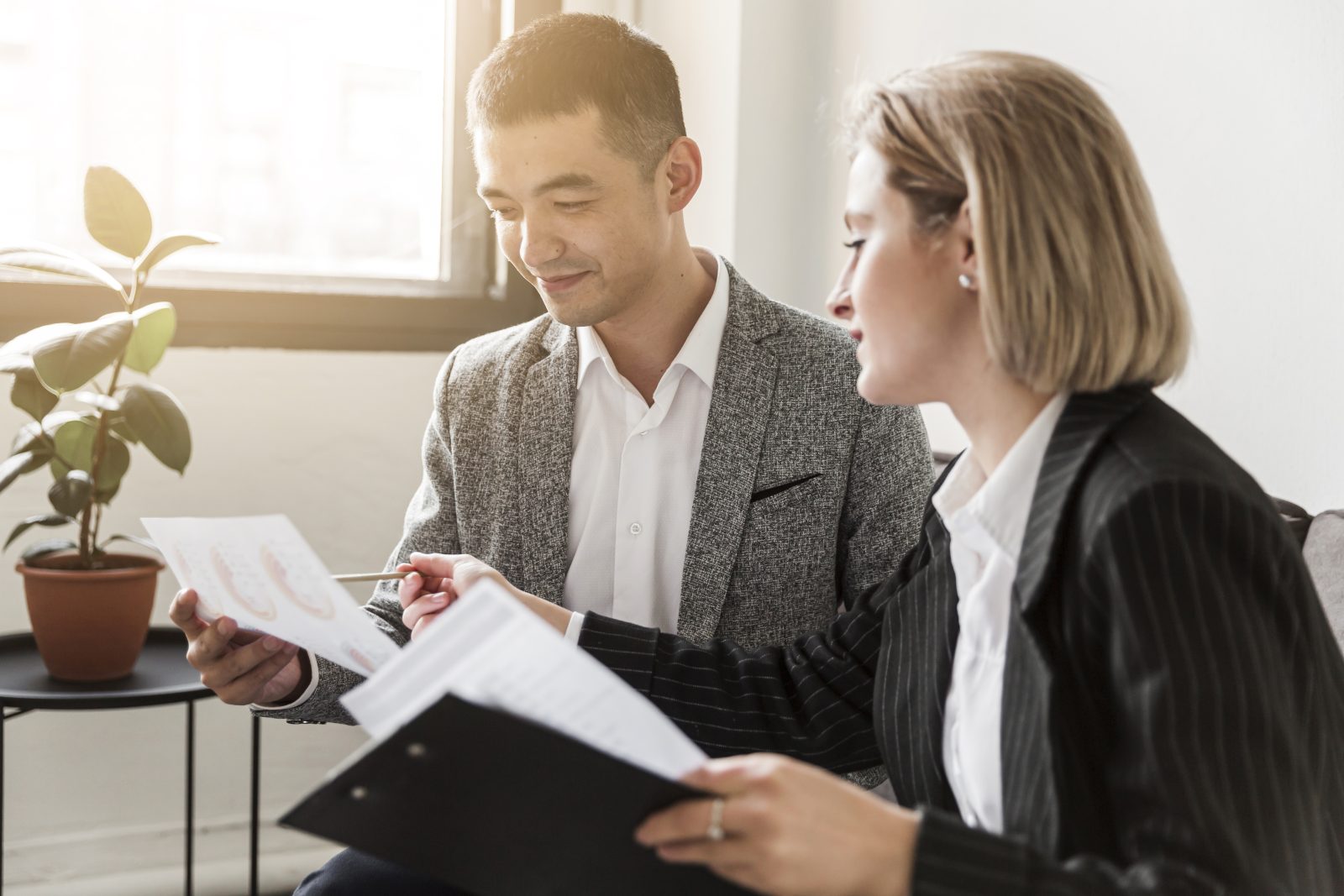 Advogada e cliente analisando relatórios em reunião, ilustrando a assessoria jurídica preventiva empresarial.