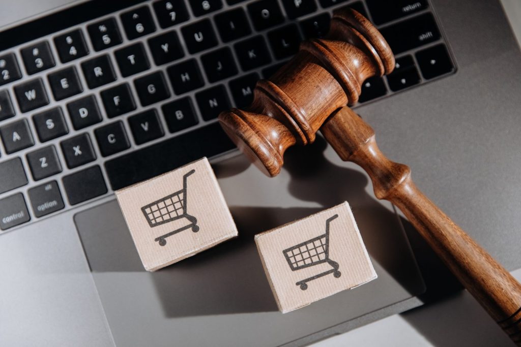 Martelo judicial sobre laptop com ícones de compras, ilustrando os direitos do consumidor em processos judiciais.