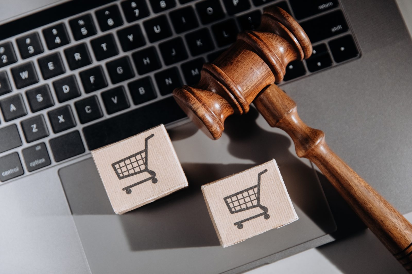 Martelo judicial sobre laptop com ícones de compras, ilustrando os direitos do consumidor em processos judiciais.