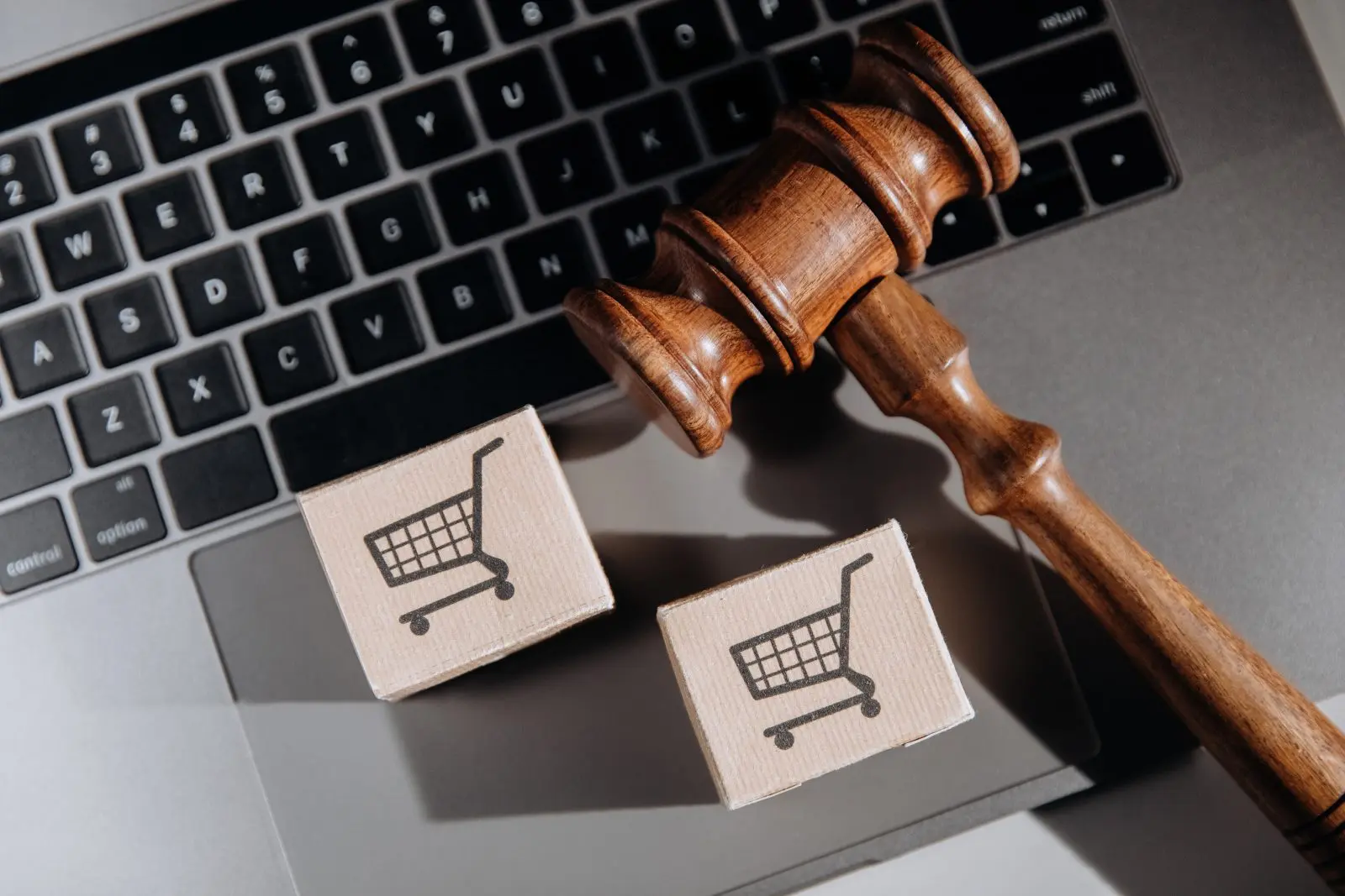 Martelo judicial sobre laptop com ícones de compras, ilustrando os direitos do consumidor em processos judiciais.